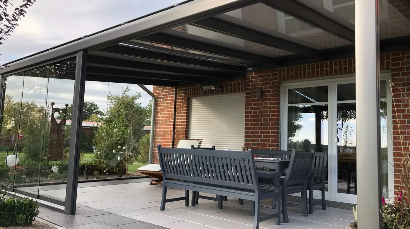 Terrassendach mit Glasschiebewänden am Abend, montiert von der Glaserei Laugesen in Verden